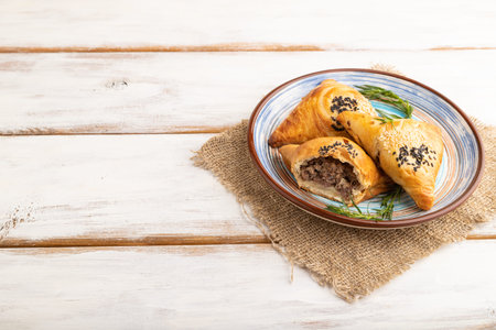 Homemade asian pastry samosa on white wooden background and linen textile. side view, copy space.の写真素材