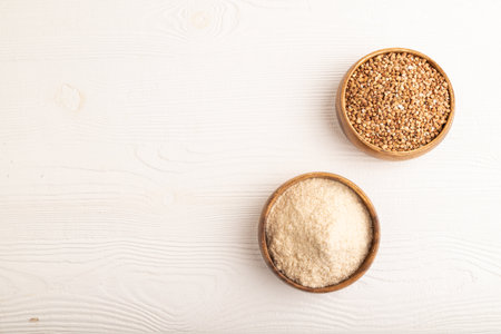 Powdered milk and buckwheat baby food mix, infant formula on white wooden background. Top view, copy space, artificial feeding concept.の写真素材