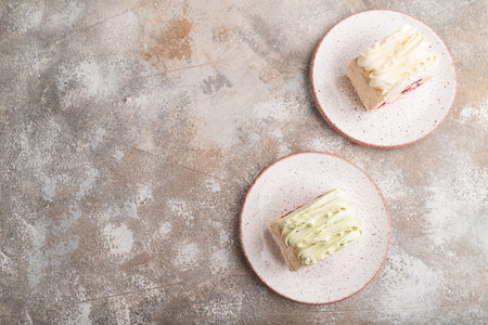 Roll biscuit cake with cream cheese and jam on brown concrete background. top view, flat lay, copy space.の写真素材