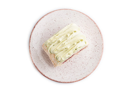 Roll biscuit cake with cream cheese and jam isolated on white background, top view, flat lay, close...