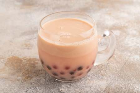 Bubble tea with pistachio and caramel in glass on brown concrete background. Healthy drink concept. Side view, close up.の写真素材