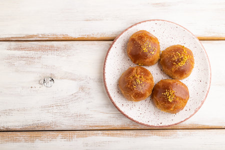 Homemade traditional Turkish dessert sekerpare with almonds and honey on white wooden background. top view, flat lay, copy space.の写真素材