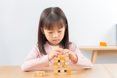 Young Asian girl with wooden puzzle, child mental health concept, autism spectrum disorder awareness concept, education, on white background, copy spaceの素材
