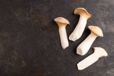 King Oyster mushrooms or Eringi (Pleurotus eryngii) on black concrete background. Top view, flat lay, copy space.の写真素材