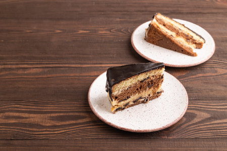 Chocolate biscuit cake with caramel cream on brown wooden background. side view, copy space.