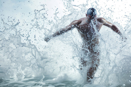 Athletic male figure surrounded by splashes of water, concept of strength, energy, endurance, freshness, freedom, cleanlinessの素材