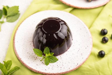 Black currant and grapes jelly on gray concrete background and green linen textile. side view, close up, selective focus.の写真素材
