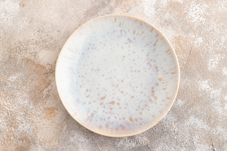 Empty blue and gold ceramic plate on brown concrete background. Top view, copy space, flat lay.の写真素材