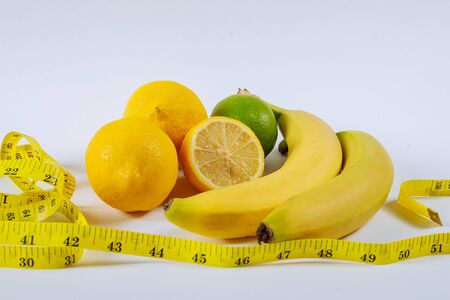Bananas, lemon, measuring tape on the table.The concept of healthy eating, weight loss.の写真素材