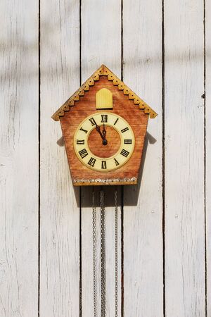Old clock on a wooden light wall.の写真素材