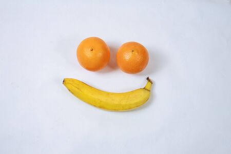 orange and banana, forming a smiley, isolated on white. Smile. Sadness.の写真素材