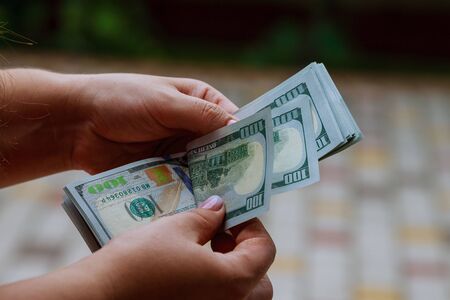 woman hands counting us dollar banknotesの写真素材