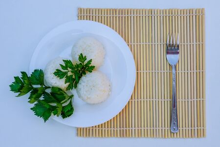 boiled rice on white plate on white backgroundの写真素材