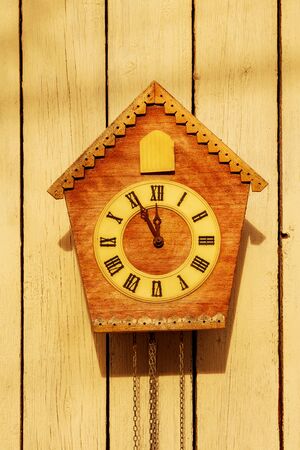 Old clock on a wooden light wall.の写真素材