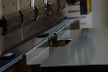 Bending sheet metal with a hydraulic bending machine at the factory.