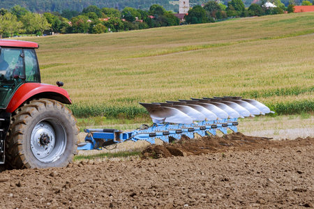 Large plow on a tractor. Tractor with agricultural attachment. Plowing the field.