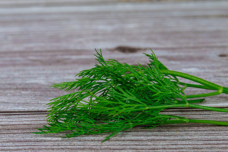 A bunch of fresh dill on a wooden table.
