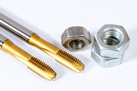 Set of tap for threading in metal. Tool for metal processing. Bolts and nuts isolated on white background.の写真素材