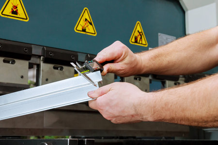 Bending sheet metal with a hydraulic bending machine at the factory. Measurement.