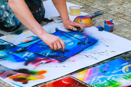 Prague, Czech Republic - April 8, 2019: A street artist paints pictures using spray cans.