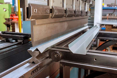 Bending sheet metal with a hydraulic bending machine at the factory.の写真素材