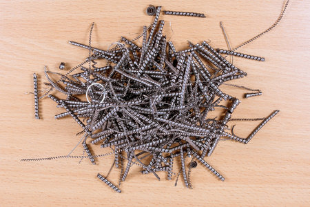 Heap of metal shavings on wooden background.