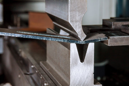 Bending sheet metal on a hydraulic machine at the factory. Bend tools, press brake punch and die....