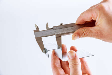 precise measurement of metal parts on a white background using a vernier caliperの写真素材