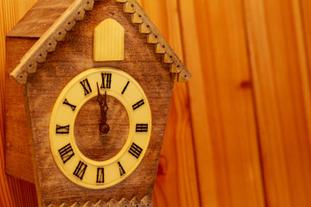 Cuckoo clock with Roman numerals on a wooden wall. Copy space. New Year.の写真素材