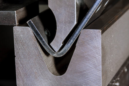 The process of bending sheet metal on a hydraulic bending machine. Metalworking plant.