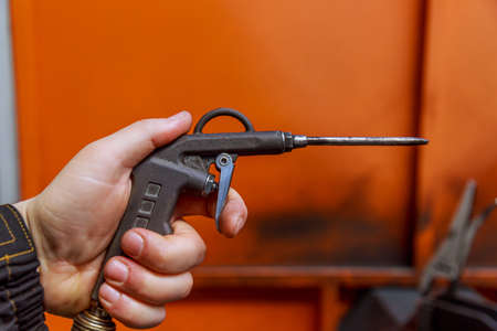 Blow gun in the hand of a worker, A gun for an air compressor in a factory.の写真素材