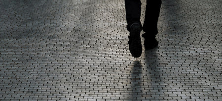 Silhouette or shadow of a man walking down the street one evening.