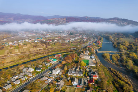 Thick morning fog over the village and the river in the mountains. Fog in the mountains on an autumn...