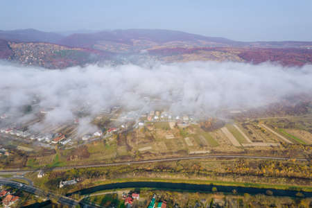 Thick morning fog over the village on an autumn day. View from above.の写真素材