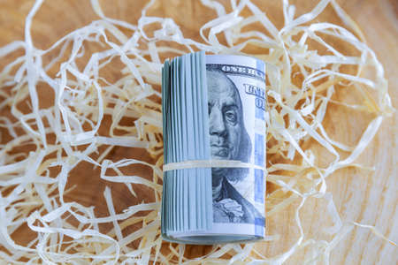 Dollars close up. Banknotes rolled into a roll with a rope. American currency. One hundred dollars.の写真素材