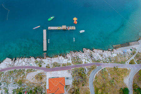 Top view of the blue Adriatic sea, catamarans in the sea, Stone beach near the sea with a walking...