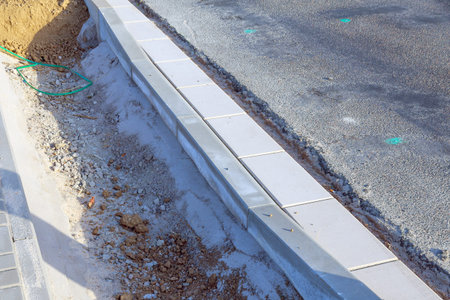 A curb near the road and a pit with clay. Repair works on the road.の写真素材