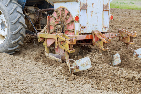 A tractor on the field plant potatoes and cultivates the ground. Growing potatoes.の写真素材