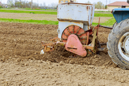 A tractor on the field plant potatoes and cultivates the ground. Growing potatoes.の写真素材