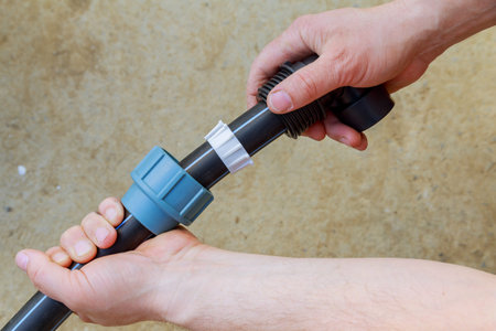 A plumber installs a connection on a polyethylene pipe