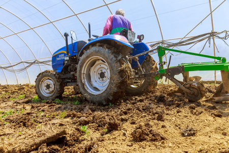 Uzhhorod, Ukraine, 10 May 2021: A farmer uses a small tractor to prepare for plowing the land in the...