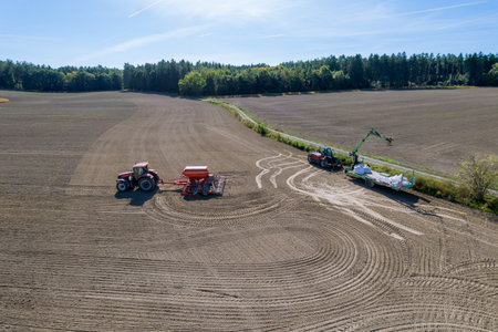 Sowing grain in the field, the tractor sows grain with the help of a seeder. Top view.の写真素材