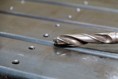 Processing of metal products and drilling holes. Metalwork concept. Drilling holes in metal pillars.