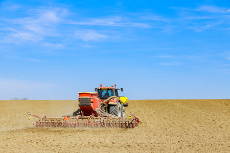 Tractor driver carefully maneuvered through field, ensuring accurate seed placement.の写真素材