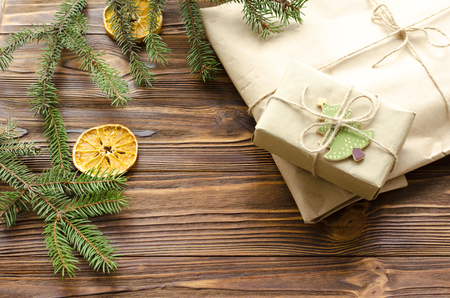 gift box and kraft paper bag on wooden table decorated fir and dry orangeの写真素材