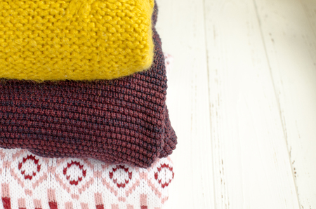 A stack of sweaters  on white wooden backgroundの写真素材