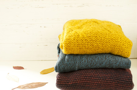 Stack of sweaters on white wooden backgroundの写真素材