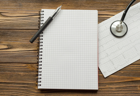 cardiogram, notebook, pen, stethoscope, wooden tableの写真素材