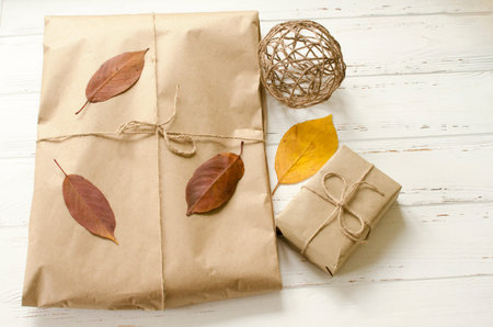 Gifts packaged in craft paper and  dry autumn leaves