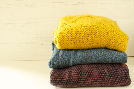  Stack of sweaters on white wooden backgroundの写真素材